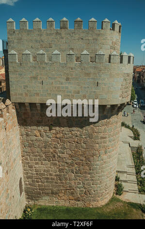 Pietra parete spessa con torre di grandi dimensioni che circonda la città accanto al giardino verde di Avila. Con un imponente muro intorno al quartiere Gotico della città in Spagna. Foto Stock