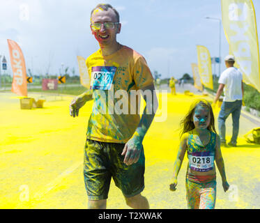 ALMATY, KAZAKHSTAN - Giugno 10, 2018: Sconosciuto famiglia insieme cosparso di vernice brillante sono sorridente al partito Yarkokros vicino all'Arena di Almaty stadi Foto Stock