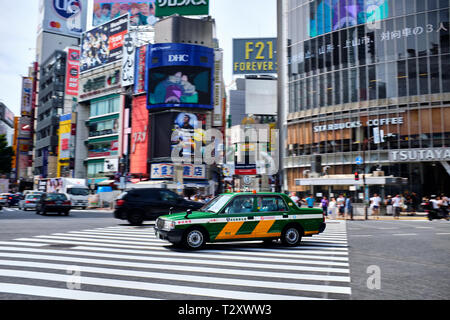 Nella foto è un taxi guida su un incrocio di Shibuya di Tokyo in Giappone. Foto Stock