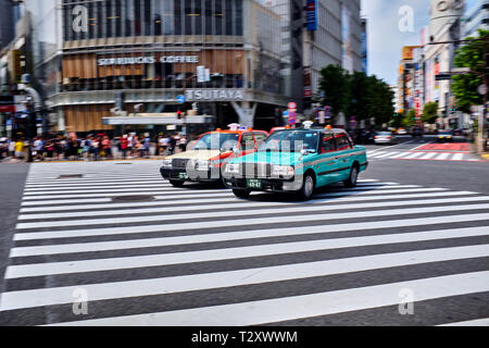 Nella foto è un taxi guida su un incrocio di Shibuya di Tokyo in Giappone. Foto Stock