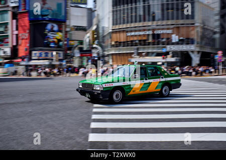 Nella foto è un taxi guida su un incrocio di Shibuya di Tokyo in Giappone. Foto Stock