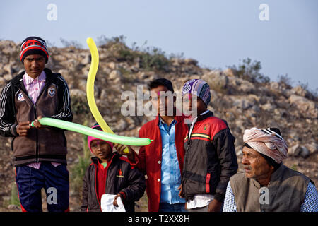 Rurale indiano ragazzi in piedi con palloncini sulla collina con il vecchio uomo. Foto Stock