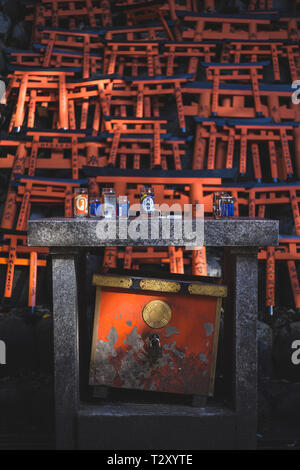 Piccolo altare con torii gates in background a Fushimi Inari santuario Foto Stock