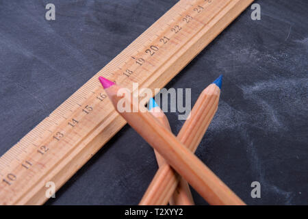 Matite di legno e un righello su una lavagna Foto Stock