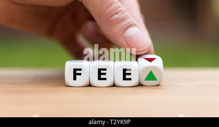 Simbolo per aumentare o diminuire le tasse. Canto diventa un dado e cambia la direzione di una freccia. Dadi forma la parola "fee". Foto Stock