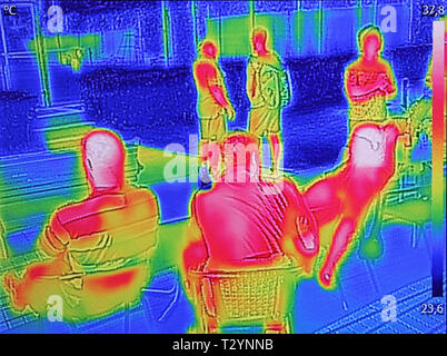 Thermovision a raggi infrarossi dell'immagine che mostra quando le persone si siedono a tavola in estate Foto Stock