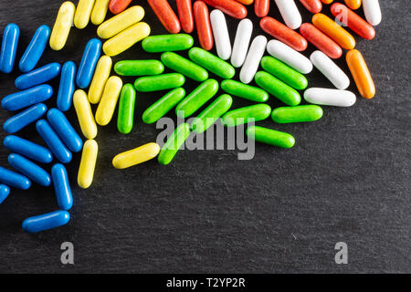 Sacco di tutta la dolce liquirizia comfit copyspace flatlay sulla pietra grigia Foto Stock