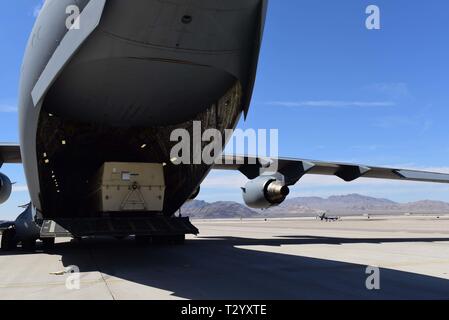Un MQ-9 Reaper pilotato a distanza aeromobile viene caricato su un C-17 Globemaster III a Creech Air Force Base in Nevada, 27 Mar, 2019. Mietitori sono ripartiti e imballati in scatole, quindi volato su aerei cargo come la C-17 in vari ambiti di responsabilità di tutto il mondo. (U.S. Air Force foto di Airman 1. Classe Haley Stevens) Foto Stock
