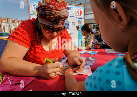 Tyumen, Russia - Agosto 26, 2016: Open Day di Sberbank per bambini. Little Girl getting glitter tattoo alla festa di compleanno Foto Stock