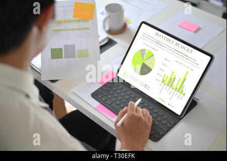 Imprenditore analisi finanziaria statistiche visualizzate sullo schermo tablet. Foto Stock