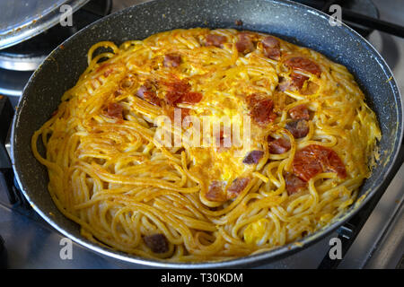Frittata di spaghetti in padella con freschi pomodori ciliegia Foto Stock