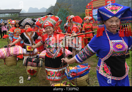 Du an, della Cina di Guangxi Zhuang Regione autonoma. 4 apr, 2019. Coloro che portano 'dowries' a scortare la "sposa" per il "nozze" durante una performance di nozze personalizzati delle Zhuang gruppo etnico in Du an Yao contea autonoma, a sud della Cina di Guangxi Zhuang Regione autonoma, 4 aprile 2019. Credito: Lu Boan/Xinhua/Alamy Live News Foto Stock
