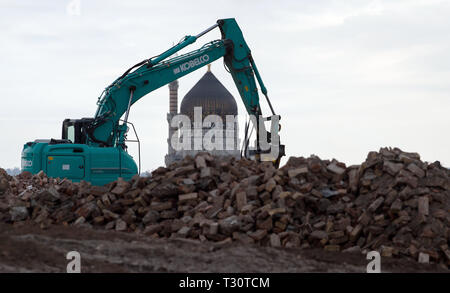 Dresden, Germania. 25 Mar, 2019. Un escavatore è occupato con lavori di demolizione del futuro sito del 'Hafencity Dresden', sullo sfondo la Yenidze, l'ex-fabbrica costruzione della fabbrica di sigarette, può essere visto. Credito: Robert Michael/dpa-Zentralbild/ZB/dpa/Alamy Live News Foto Stock