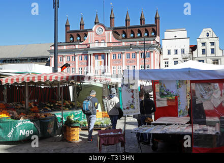 Rostock, Germania. 1 Aprile, 2019. Sul Neuer Markt, il tradizionale mercato settimanale avviene per sei giorni a settimana, con il municipio in background. Il Rostock mercati settimanali possono essere trovati a quattordici sedi nella città anseatica. Credito: Bernd Wüstneck/dpa/ZB/dpa/Alamy Live News Foto Stock