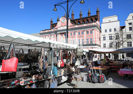 Rostock, Germania. 1 Aprile, 2019. Sul Neuer Markt, il tradizionale mercato settimanale avviene per sei giorni a settimana, con il municipio in background. Il Rostock mercati settimanali possono essere trovati a quattordici sedi nella città anseatica. Credito: Bernd Wüstneck/dpa/ZB/dpa/Alamy Live News Foto Stock