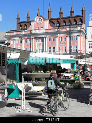 Rostock, Germania. 1 Aprile, 2019. Sul Neuer Markt, il tradizionale mercato settimanale avviene per sei giorni a settimana, con il municipio in background. Il Rostock mercati settimanali possono essere trovati a quattordici sedi nella città anseatica. Credito: Bernd Wüstneck/dpa/Alamy Live News Foto Stock