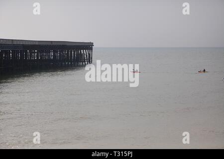 Hastings, East Sussex, Regno Unito. 06 apr, 2019. Regno Unito: clima mite ma coperto nella cittadina balneare di Hastings in East Sussex questa mattina, alti di 12 gradi centigradi. Approccio Kayakers l'Hastings pier nelle calme acque del mare. © Paul Lawrenson 2019, Photo credit: Paolo Lawrenson/Alamy Live News Foto Stock