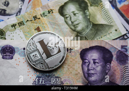 Argento Litecoin LTC su yuan cinese e dollari USA banconote. Close-up. Foto Stock