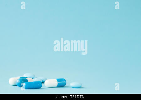 Blu pillole e capsule su sfondo blu con una copia dello spazio. Foto Stock