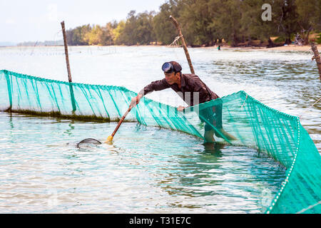 Locale pescatore vietnamita usando una mano net e reti da pesca off shore a Bai Dai Tay spiaggia nel Golfo di Thailandia, Phu Quoc Island, in Vietnam, in Asia. Foto Stock