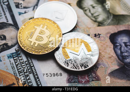 Bitcoin BTC, Ethereum ETH, Monero XMR delle monete il yuan cinese e dollari USA banconote. Close-up Foto Stock