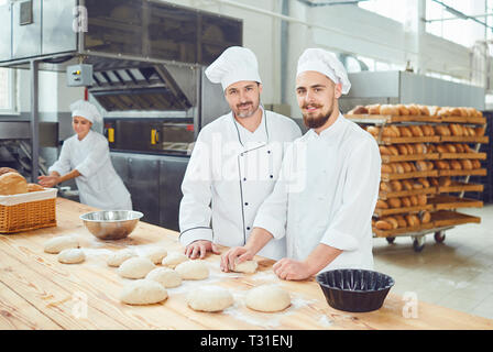 Gli uomini bakers sul posto di lavoro in pasticceria Foto Stock