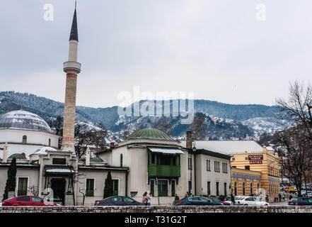 Un minareto sorge su edifici attraverso il fiume dalla città vecchia di Sarajevo, Bosnia Erzegovina Foto Stock