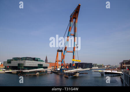 Copenhagen, Danimarca - 4 Aprile 2019: l'enorme gru galleggiante Hebo sollevare 9 installazione di parti per un nuovo ponte in bicicletta sul porto. Foto Stock