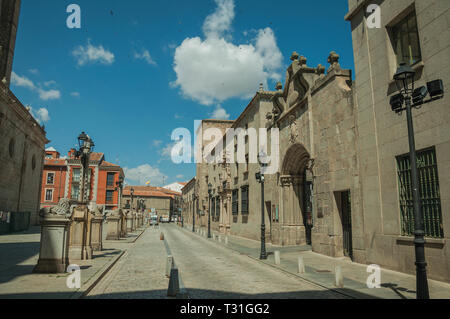 Stone street e palazzo gotico ornato di arco, in una giornata di sole a Avila. Con un imponente muro intorno al quartiere Gotico della città in Spagna. Foto Stock