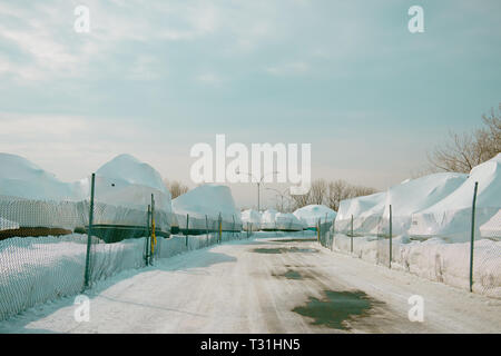 Barche winterized in una corte di storage. Neve. Stagione invernale Foto Stock