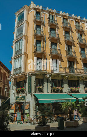 Affascinante vecchio edificio con eatery e gente che cammina su una strada tranquilla in Madrid. Capitale della Spagna con vibrante e intensa vita culturale. Foto Stock