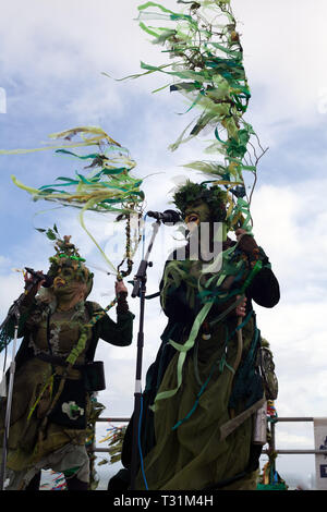 Banda femmina cantando nella loro favolosa costumi verde sul palco a West Hill durante il martinetto nel festival verdi, Hastings, East Sussex, Regno Unito Foto Stock