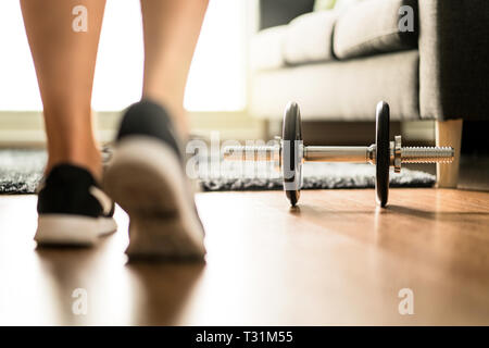 Motivazione di workout, determinazione di idoneità e concetto di esercitarsi. Allenamento mattutino alla luce del sole. Persona con attrezzature da palestra a casa. Foto Stock