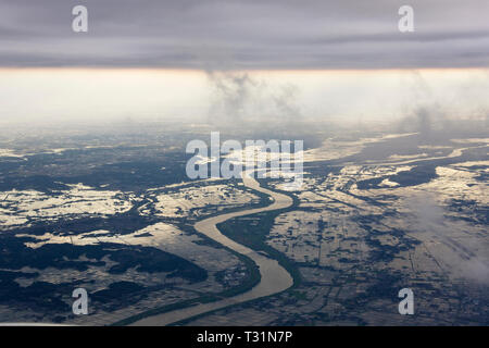Fiume che scorre attraverso un paesaggio inondato Foto Stock