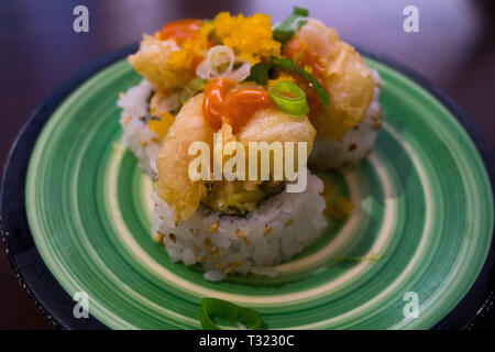 Gamberi fritti rotolo di sushi su una piastra verde Foto Stock