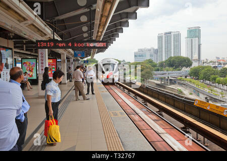 Kuala Lumpur, Malesia, Rapid KL Light Railway, trasporto in treno arrivando alla stazione di " commuters " piattaforma, pendolari in attesa di bordo. Foto Stock