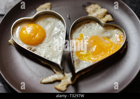 Uova strapazzate nei cuori. Tema d'amore Foto Stock