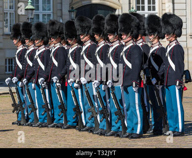 Truppe della Reale Danese di vita delle guardie stand presso l attenzione sul parade presso il Palazzo Amalienborg, durante il cambio della guardia. Foto Stock