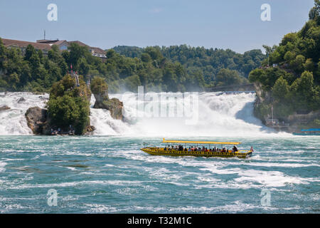 Schaffhausen, Svizzera - 20 Giugno 2017: Vista Cascate del Reno è la cascata più grande in Europa e la gente in barca intorno ad esso. Giorno di estate in blu Foto Stock