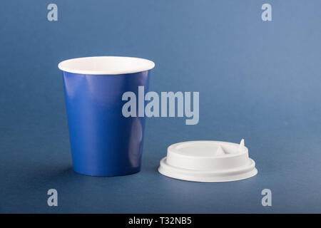 Blue tazza monouso con tappo bianco su sfondo blu. Foto Stock