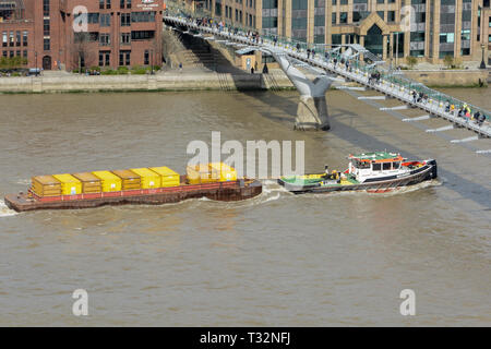 Londra rimorchiatore a traino il recupero passa sotto il Millenium Bridge vicino la Cattedrale di St Paul e sul fiume Thames, London, Regno Unito Foto Stock