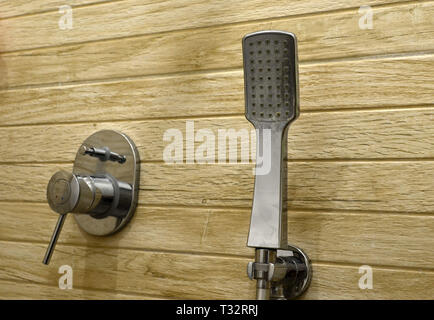 Chrome doccia testa su uno sfondo di piastrelle in legno Foto Stock