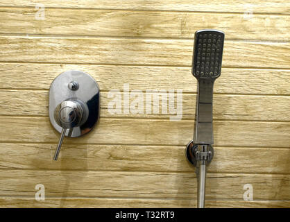 Chrome doccia testa su uno sfondo di piastrelle in legno Foto Stock
