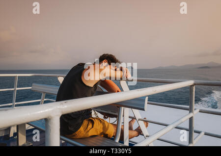 Giovane uomo dormire su di una nave da crociera nei pressi di Koh Tao Island, Thailandia Foto Stock