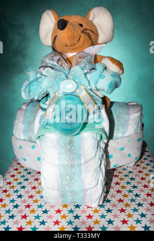 Torta di pannolini un pannolino torta triciclo con nastri azzurri. Regalo per la nascita di un bambino Foto Stock