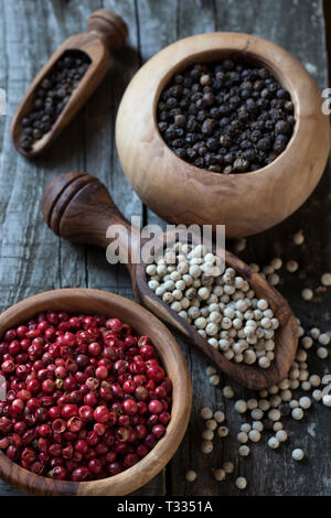 Bianco, nero e pepe rosso su sfondo di legno Foto Stock
