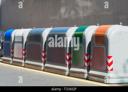 Fila di contenitori per la raccolta differenziata di vetro, carta e alluminio in strada Foto Stock