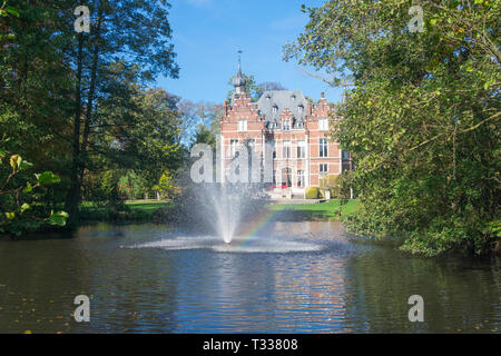 Waasmunster, Belgio - 13 ottobre 2018, Castello Blauwendael con fontana e Rainbow in primo piano Foto Stock