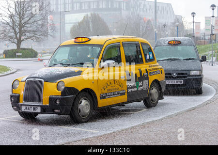 Solihull Birmingham West Midlands England Regno Unito 17 marzo 2019 giallo brillante nero tradizionali taxi presso il National Exhibition Centre di forte grandine Foto Stock