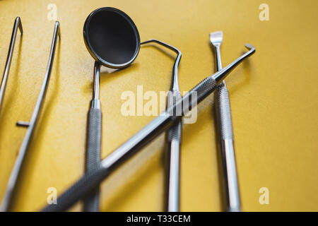 Close-up Strumenti Dentali su sfondo giallo. La prevenzione di malattie orali. Foto Stock